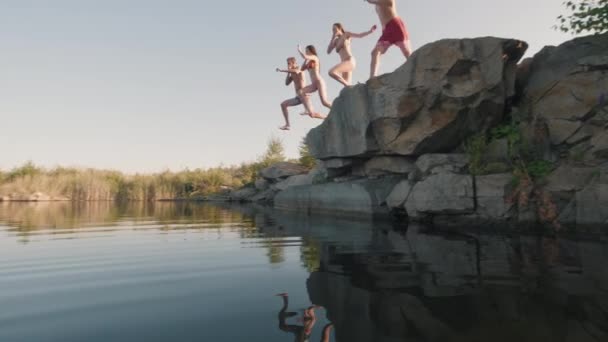 去年夏天 Pan和一群穿着泳衣的年轻人跳下悬崖跳入湖中 动作缓慢 — 图库视频影像