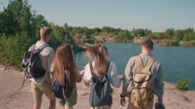 Sırt çantalı gençlerin, göle bakan küçük uçurumun kenarına yürürken ve manzaranın tadını çıkarırken çekilen dikiz görüntülerini izliyorum.