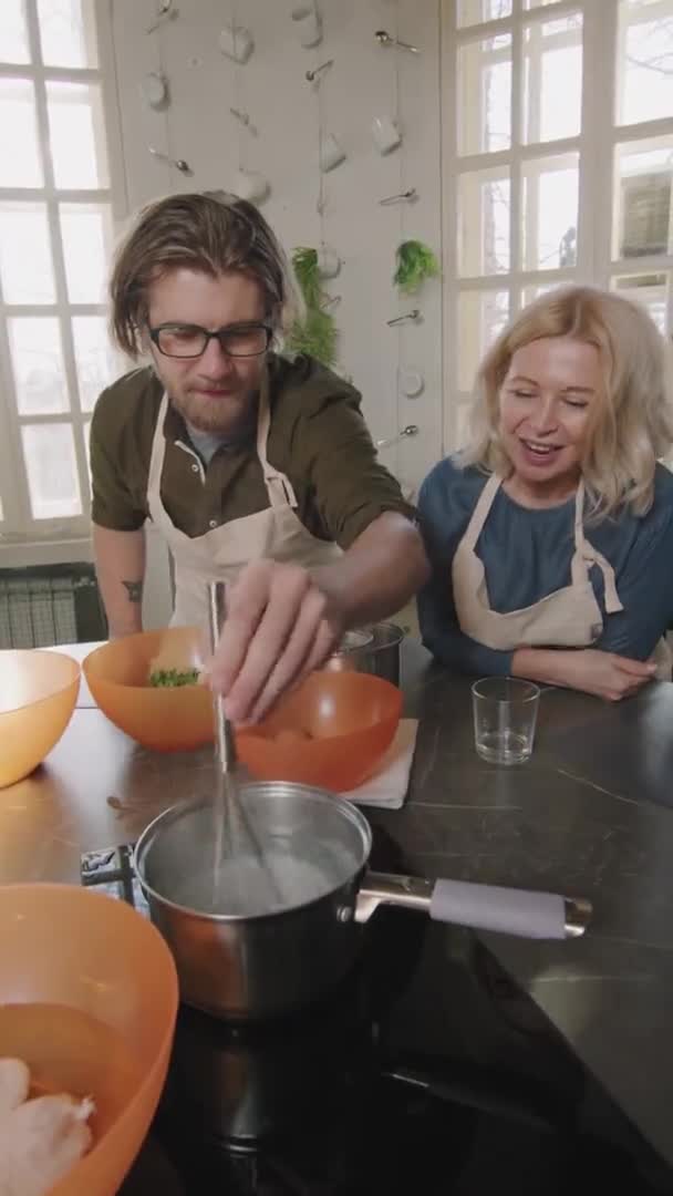 烹饪大师课上 男人和女人在一起煮煮煮鸡蛋的慢动作垂直中镜头 — 图库视频影像