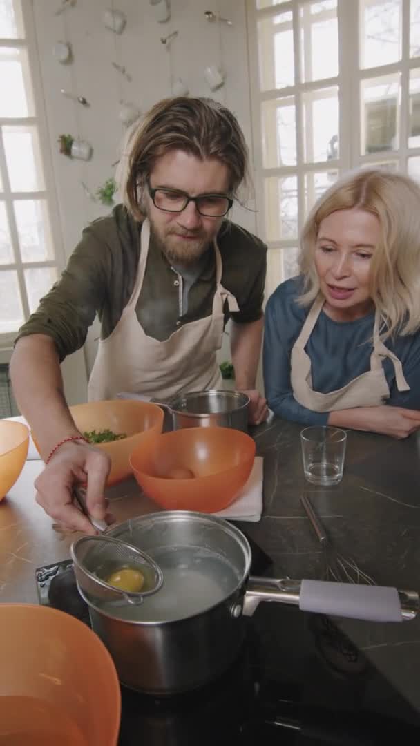 Yavaş Çekimde Genç Adamın Haşlanmış Yumurta Pişirirken Onu Kaynar Suyla — Stok video
