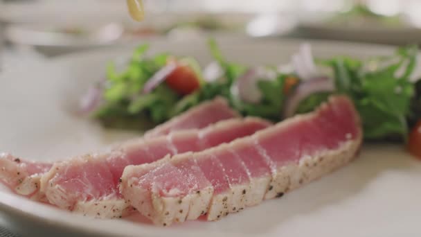 Zbliżenie Nierozpoznawalny Szef Kuchni Posypywania Sosem Pyszne Plasterki Smażonego Tuńczyka — Wideo stockowe