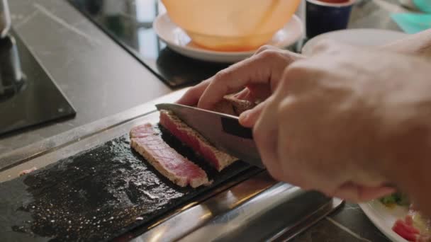 目に見えない男性の手をゆっくりと閉じてから調理クラスでスライスでマグロのステーキを切断 — ストック動画