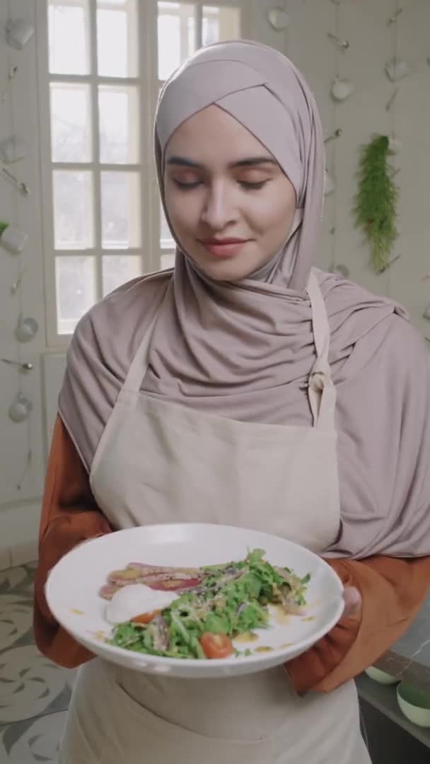 Вертикальний Портрет Красивої Молодої Мусульманки Посміхаючись Камері Тримає Смачну Самостійно — стокове відео