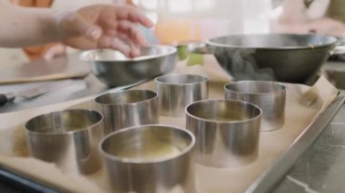 Aşçılık sınıfında ana sınıfı gösteren lazanya oluşturmak için paslanmaz halka kalıpları kullanan tanınmayan şefin yakın çekim görüntüsü.