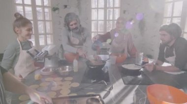 Yavaş çekimde erkek şefin çeşitli öğrencilerine yemek kursunda lazanya pişirmeyi öğretirken.