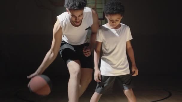 Handheld Śledzenie Strzał Męski Koszykarz Pokazując Ucząc Małego Syna Jak — Wideo stockowe