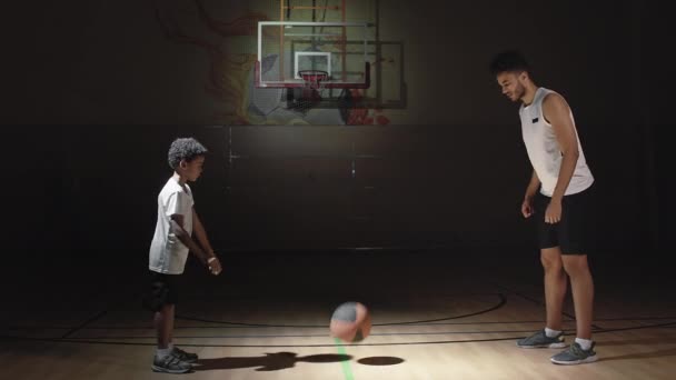 Μέτριο Πλάνο Ενός Νεαρού Μαύρου Μπασκετμπολίστα Και Ενός Αγοριού Αθλητικά — Αρχείο Βίντεο
