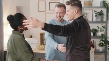 Samimi bir dairede gülümseyen ve kucaklaşan mutlu erkek ve kadınların yavaşlaması.