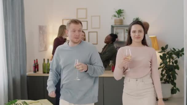 中镜头中 快乐的男男女女举着盛满白葡萄酒的酒杯 一起跳着愚蠢的舞步 然后在镜头前敬酒 — 图库视频影像