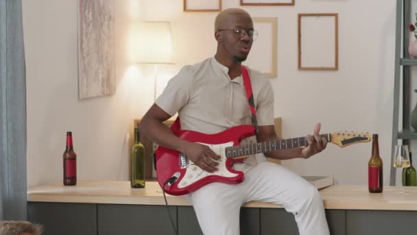 Pan Tiro Jovem Negro Sentado Balcão Tocando Guitarra Elétrica Apartamento — Vídeo de Stock