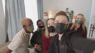 Genç erkek ve kadınların yüz maskeleri takıp evde selfie çektikleri pov fotoğrafları.