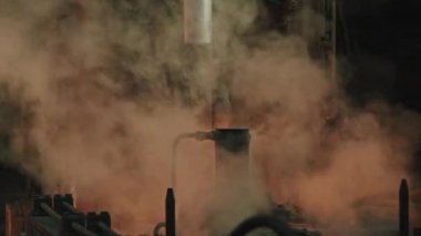 Tehlikeli ağır makine teçhizatı ve sıcak çelikle çalışan bir sürü duman ve ısıtma atölyesi.