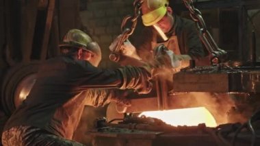 Yüz kalkanları çelik demircilik makinesiyle çalışan iki demircinin orta boy fotoğrafı.