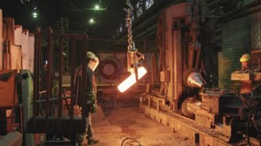 Profesyonel erkek mühendislerin iş kıyafetleri ve yüz kalkanları ile birlikte çalışan sert şapkalıların orta boy fotoğrafı. Sahte çelik imalatı yapan sahte yüzüklerle birlikte makine teçhizatı kullanılarak sahtelenmiş.