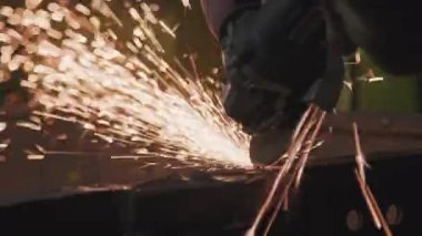 Tanımlanamayan erkek elleri kaynak makinesini tutuyor. Traktör fabrikasında metalle çalışıyor.