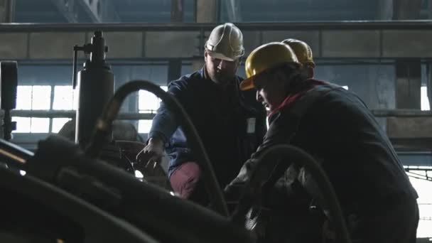 Tiro Médio Três Trabalhadores Fábrica Tratores Macacões Capacetes Por Equipamento — Vídeo de Stock