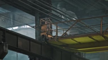 Traktör fabrikasının dökümhanesinde ağır yük taşımak için kullanılan büyük kazıcı vinci