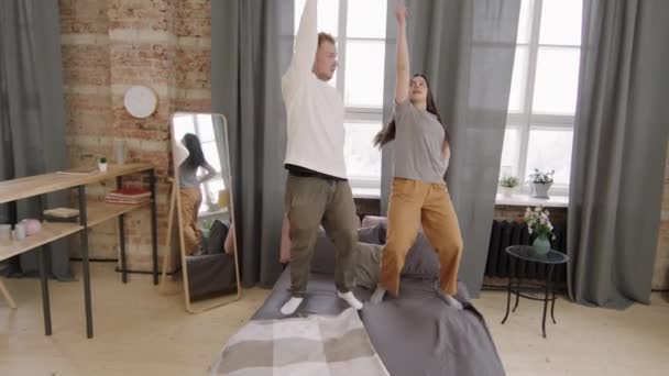 Rastreamento Tiro Feliz Jovem Casal Dançando Cama Seu Apartamento Loft — Vídeo de Stock