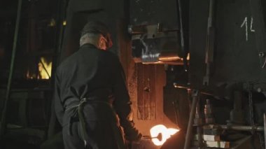 Dikiz ayarı, kızgın çelikle çalışan demir fabrikası işçilerinin orta ölçekli görüntüsü.