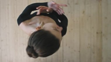 Genç ve zarif balerinin boş stüdyoda dans ederken, zarif bir şekilde dans edişinin en iyi görüntüsü.