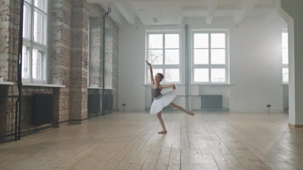 在宽敞的阁楼风格的舞蹈课上独自跳白色塔图舞的可爱的小芭蕾舞演员的全景 — 图库视频影像