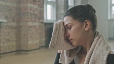 Dans okulunda yapılan sert bale eğitiminden sonra alnından ter silen genç balerin.