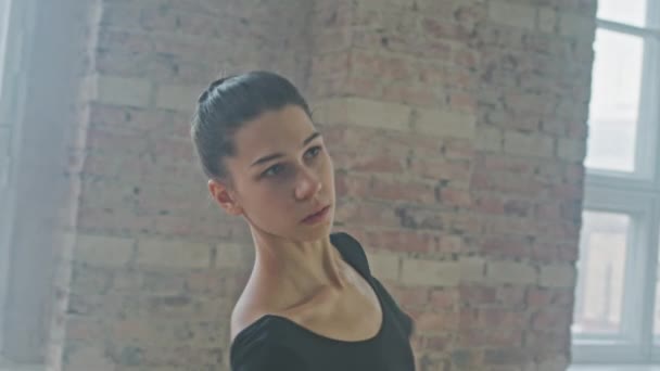 在空荡荡的芭蕾舞课上穿着黑色体衣优雅地跳舞的性感年轻芭蕾舞演员的中镜头 — 图库视频影像