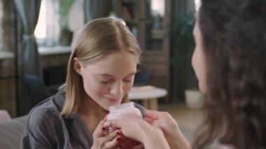 Kafkas kökenli genç bir kadının, doğal çilek vücut yağının tadını çıkarırken, kadın arkadaşlarının oturma odasında pijama partisinde iyi vakit geçirdiği orta ölçekli bir yakın çekim.