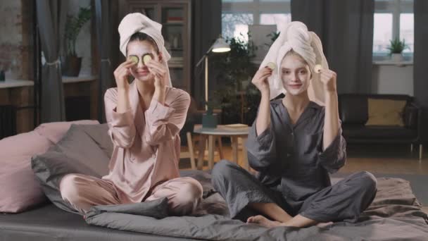 Medium Skott Två Unga Kvinnliga Vänner Pyjamas Sitter Sängen Bär — Stockvideo