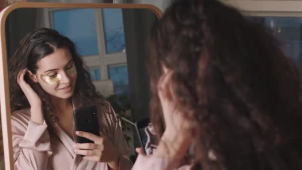 곱슬곱슬 머리의 아름다운 스마트폰으로 셀카를 그녀의 아름다움을 즐기는 모습이 떠오르고 — 비디오