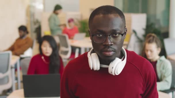 Портрет Афро Американского Бизнесмена Очках Наушниках Шее Смотрящего Камеру Офисе — стоковое видео