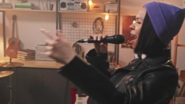 Geri-stil stüdyoda rock müzik çalan genç ve havalı müzik grubunun el bilgisayarı yavaşlığı. Zarif bereli ve deri ceketli çekici vokalist mikrofonda duygusal bir şekilde şarkı söylüyor.