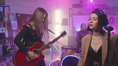 Gece kulübünde rock yapan ve sahnede müzik enstrümanları çalan havalı, enerjik bir müzik grubu.