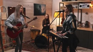 Davulcu, gitarist ve piyanistten oluşan ve duvarlarında ünlü müzisyenlerin posterleriyle retro-stil bir stüdyoda şarkı söyleyen genç ve enerjik bir müzik grubu.