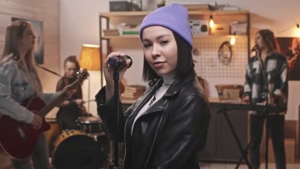 Mor Bereli Siyah Deri Ceketli Genç Bir Kadının Mikrofon Içinde — Stok video