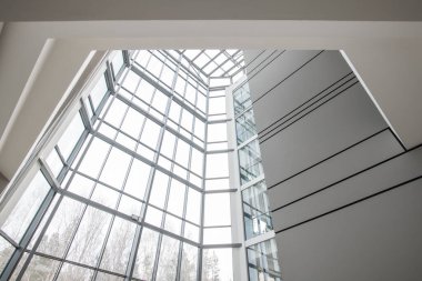 Çağdaş iş salonundaki çıplak ağaçlara bakan panoramik pencere