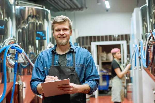 Ung Skäggig Manlig Arbetare Stora Samtida Bryggeri Gör Anteckningar Samtidigt — Stockfoto