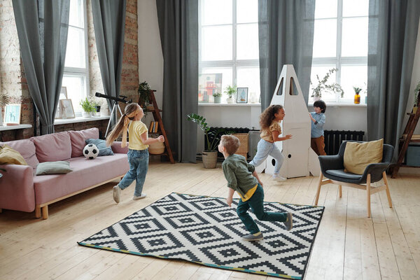 Group of children running around the room and playing together in the room