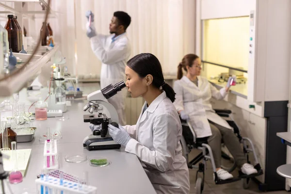 Joven Mujer Asiática Mirando Través Del Microscopio Sentada Mesa Con — Foto de Stock