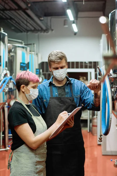 Dos Jóvenes Trabajadores Gran Fábrica Producción Cerveza Contemporánea Discutiendo Notas —  Fotos de Stock