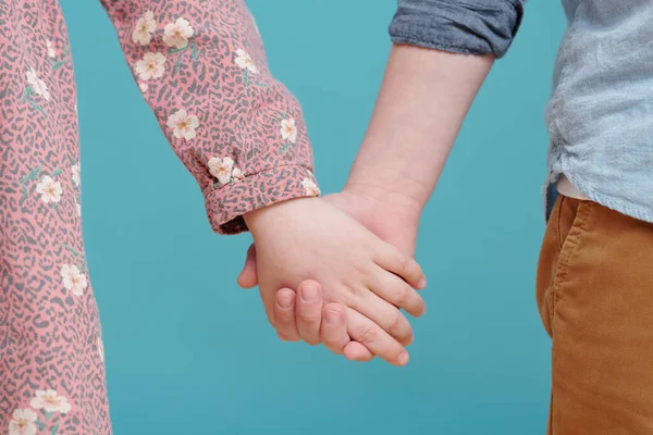 Zbliżenie Małego Chłopca Dziewczynki Trzymających Się Ręce Stojących Niebieskim Tle — Zdjęcie stockowe