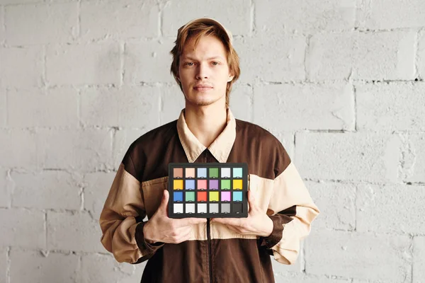 Σοβαρός Νεαρός Άνδρας Workwear Κρατώντας Τετράγωνο Παλέτα Δείγματα Χρώματος Ενώ — Φωτογραφία Αρχείου