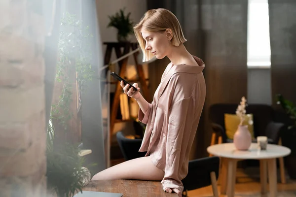 Jovem Bela Mulher Lendo Livro Line Seu Telefone Celular Sala — Fotografia de Stock