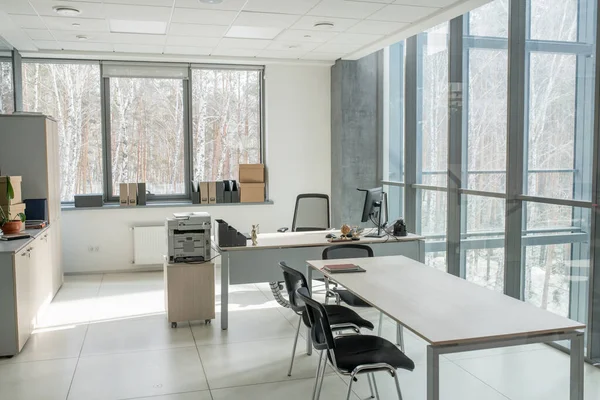 ビジネスセンターのパノラマの壁を持つ小さなオープンスペースオフィス コンピュータとスキャナーを備えたデスク 交渉のための長いテーブル — ストック写真