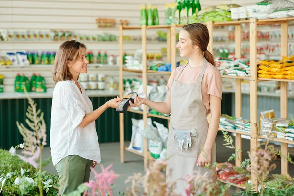 Asistente Tienda Joven Feliz Mirando Cliente Femenino Que Sostiene Tarjeta —  Fotos de Stock