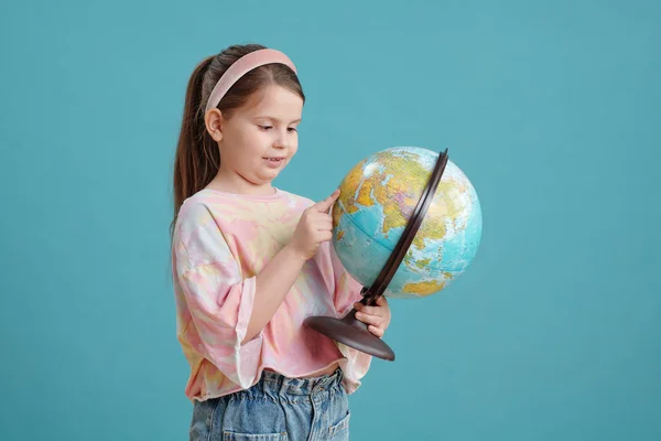 Linda Niña Sosteniendo Globo Sus Manos Examinándolo Pie Sobre Fondo — Foto de Stock