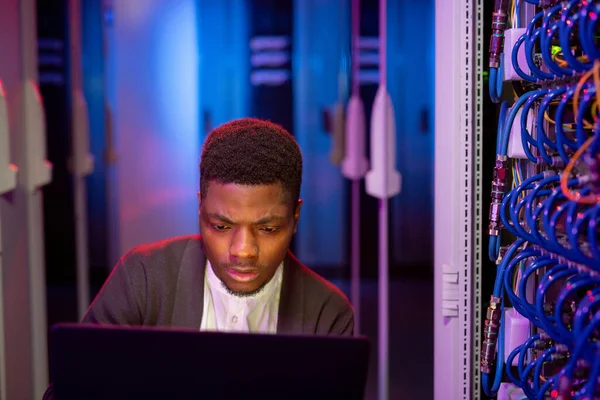 Ocupado Jovem Engenheiro Preto Usando Laptop Moderno Sala Servidores Enquanto — Fotografia de Stock