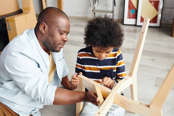 Young African Man Helping His Adorable Little Son Screwing Nail — Stock Photo, Image