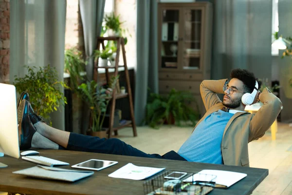 Relaxado Jovem Empresário Preto Óculos Sentado Com Pés Mesa Ouvir — Fotografia de Stock