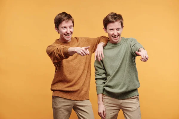 Jóvenes Preadolescentes Positivos Suéteres Riendo Mientras Señalan Algo Contra Fondo — Foto de Stock